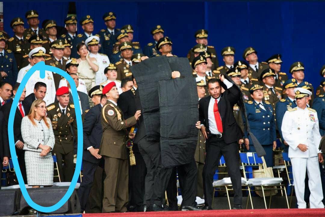 Protecting the President behind protecting shields deployed by security. The first lady is in blue circle.