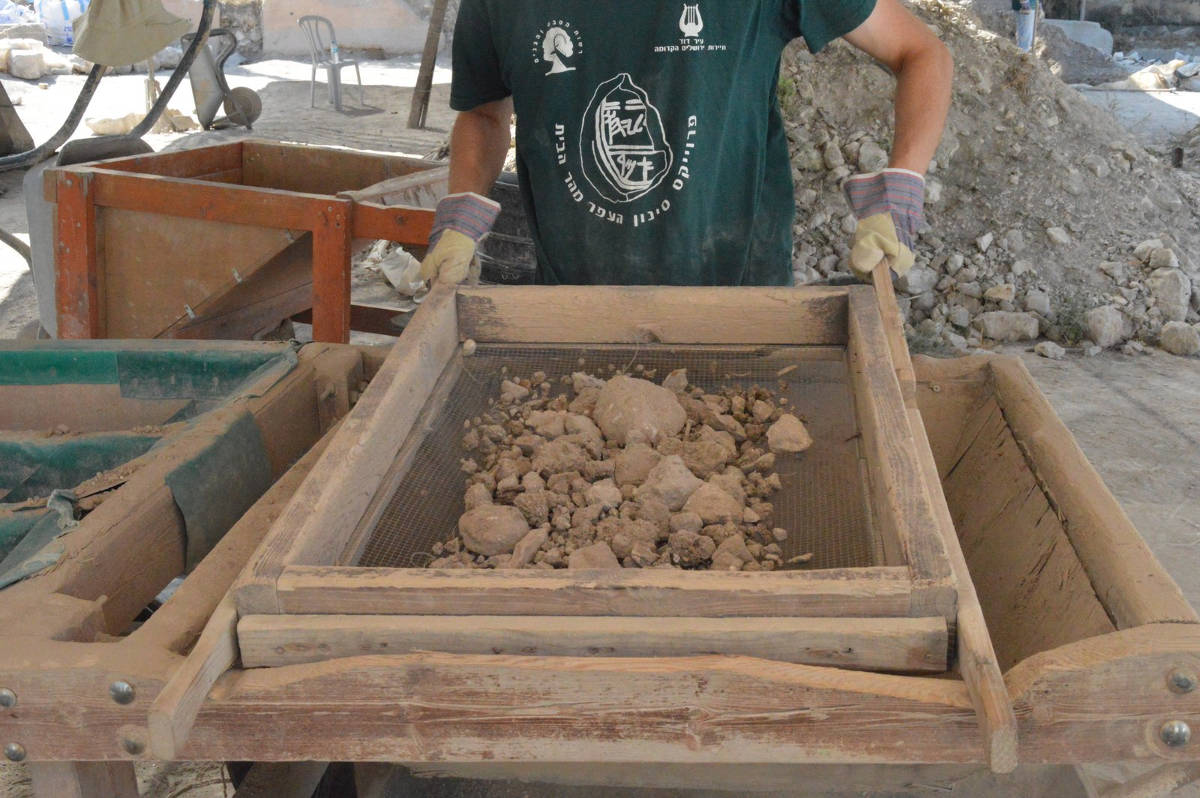Sifting in front from some of the earth containing finds from the Temple Mount in Israel.