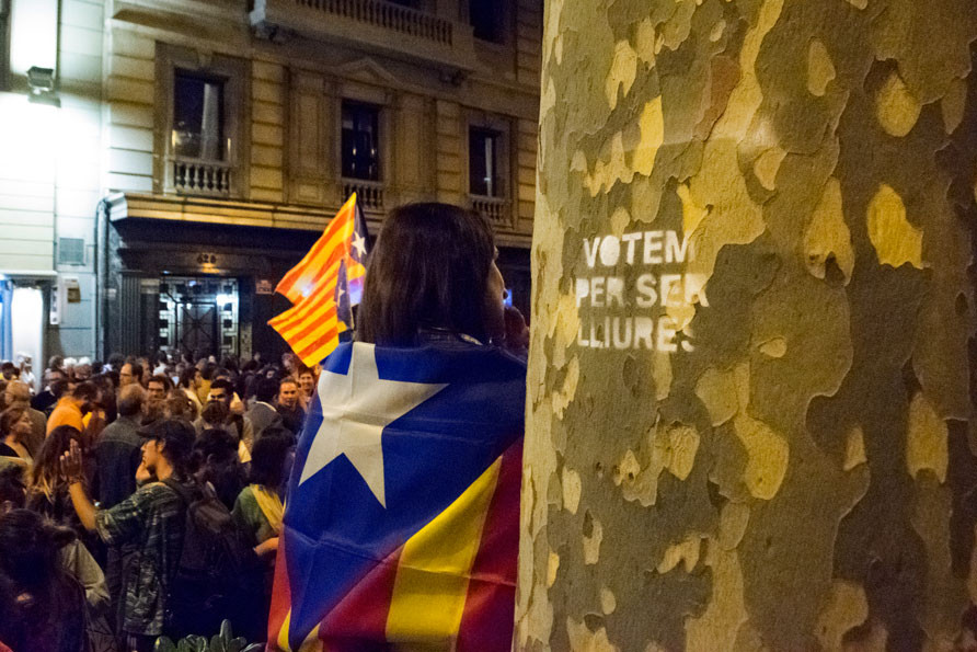 Girl with Catalonia flag. Pro-Catalan Independence demonstrators organize before regional elections. "Vote to be free" is written on the tree. Photo by: Evan McCaffrey.