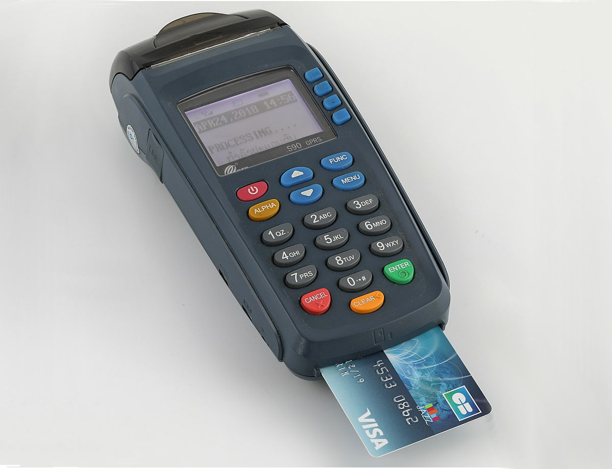 Processing credit card terminal with a visa card inserted. Photo by: Basile Morin.